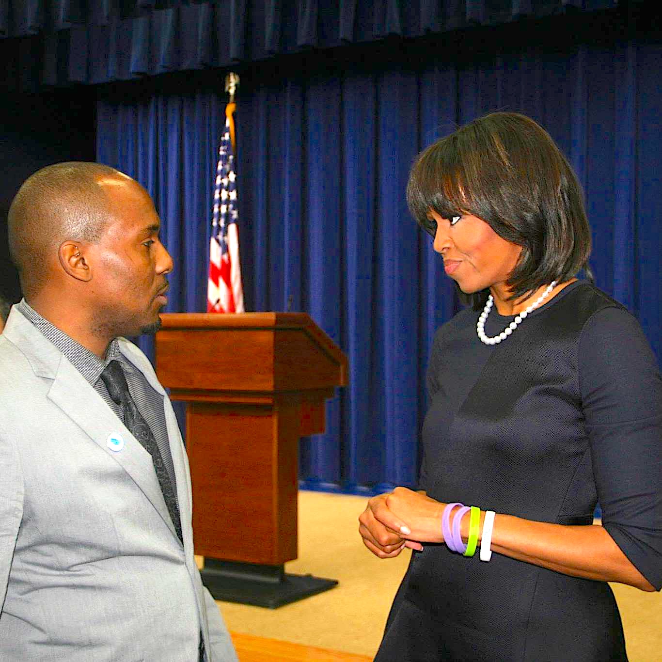 Chris Foye in conversation with First Lady Michelle Obama at the White House podium, 2013